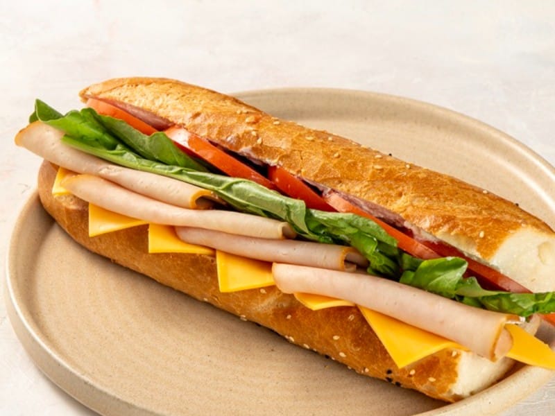 Hindi X Cheddar sandviç: baget ekmeğinde hindi füme, cheddar, domates ve roka